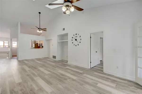 an empty room with fan and windows