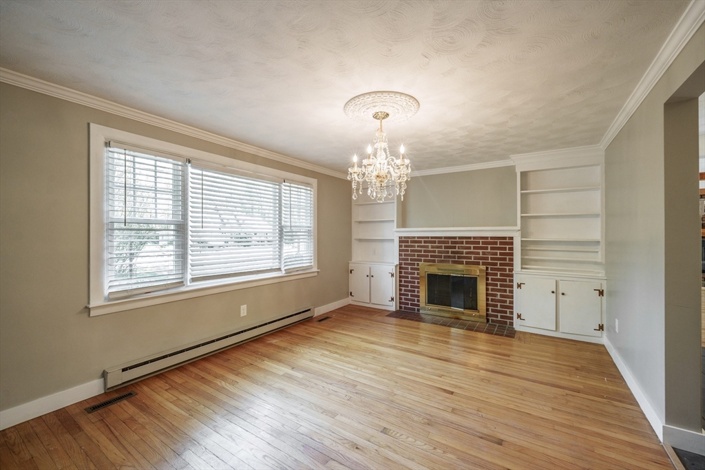 313 Bennett Road Hampden, MA 01036 - Photo 18 of 42 an empty room with wooden floor fireplace and windows