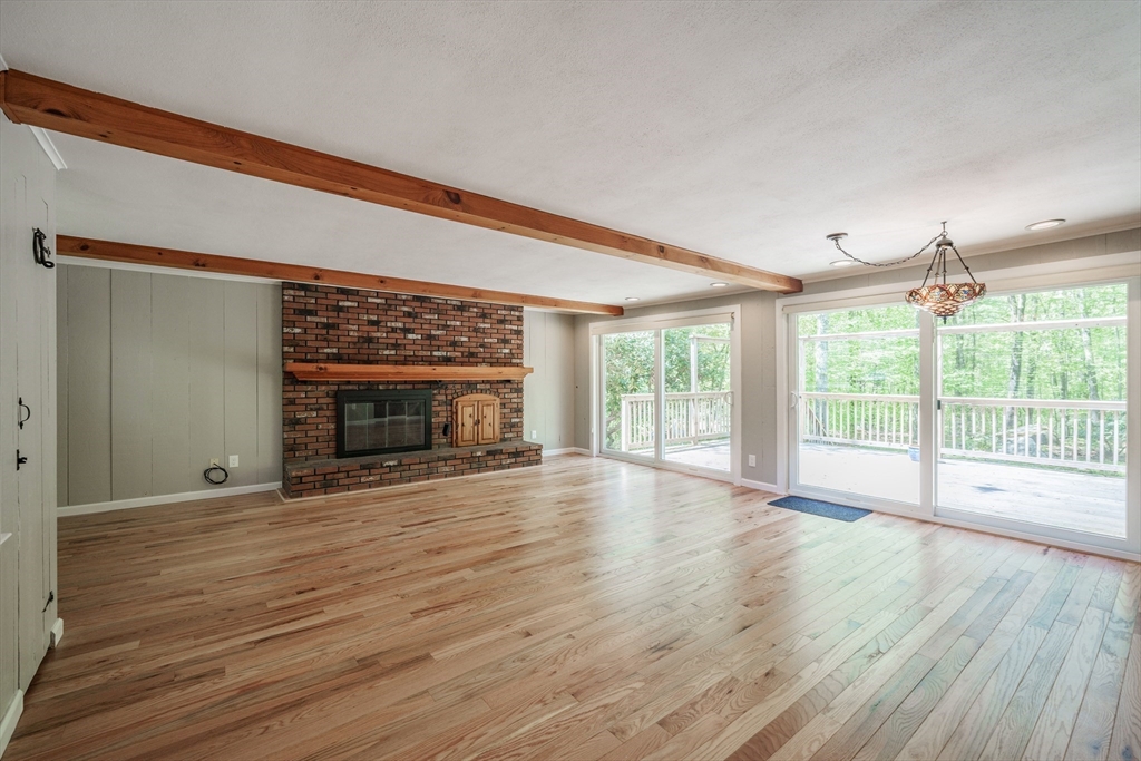313 Bennett Road Hampden, MA 01036 - Photo 8 of 42 a view of an empty room with wooden floor and a fireplace