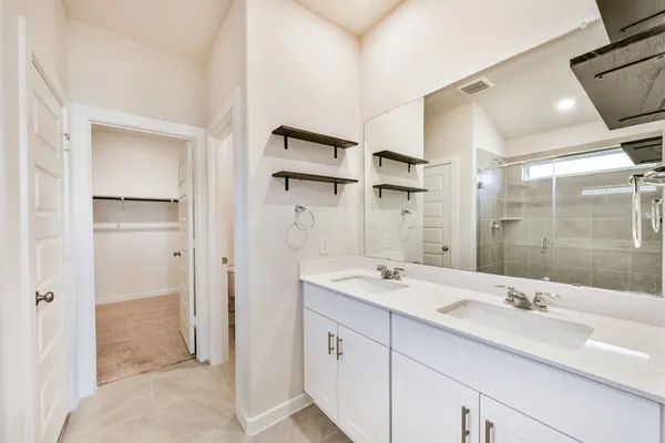a bathroom with a double vanity sink mirror and shower