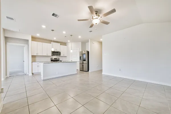 a large white kitchen with cabinets and stainless steel appliances