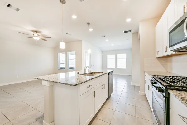 a kitchen with a sink stove and cabinets