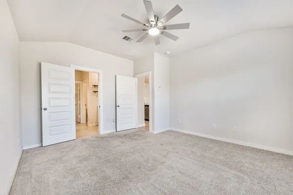 an empty room with closet and a ceiling fan