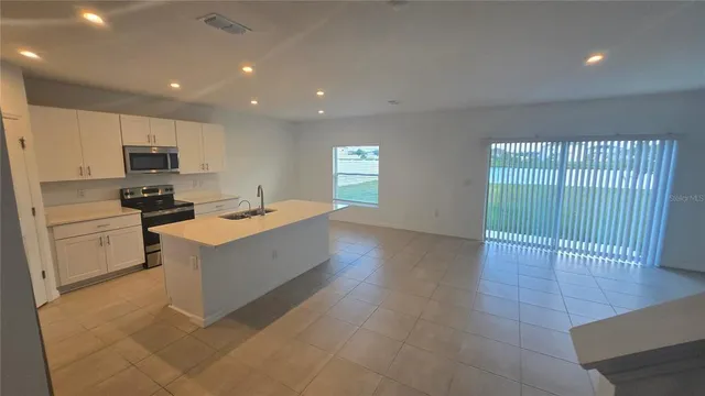 a kitchen with stainless steel appliances a sink stove and cabinets