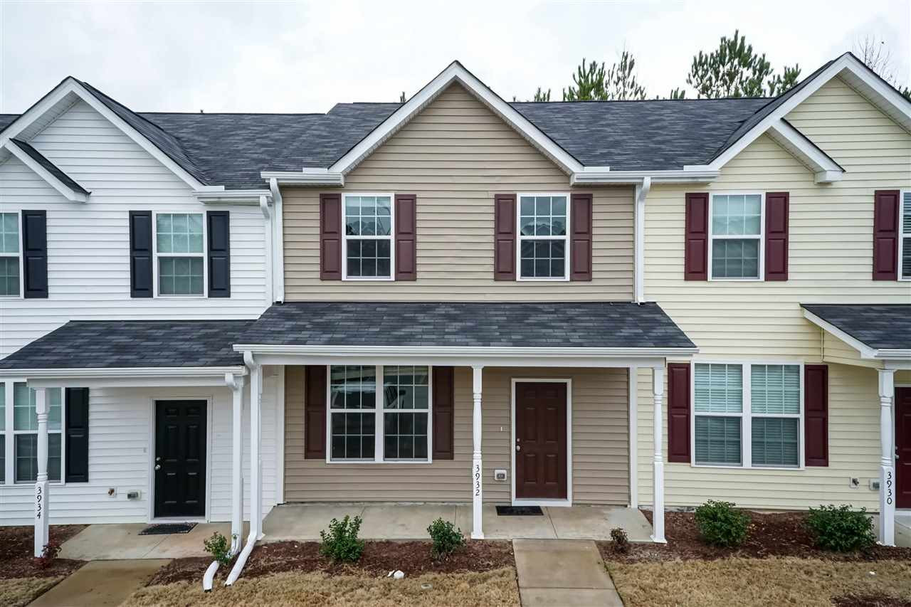 3934 Volkswalk Place Raleigh, NC 27610 - Photo 2 of 16 a view of a brick house with large windows and a yard