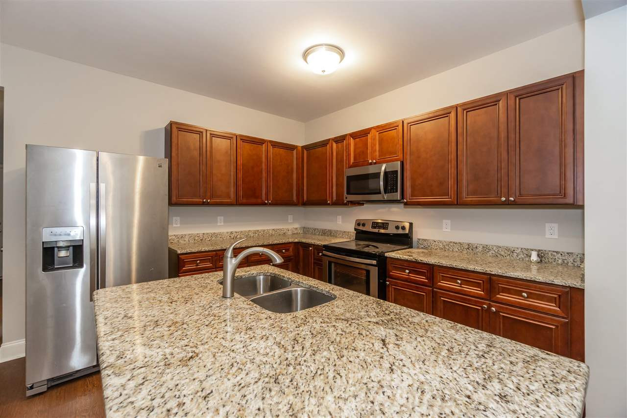 3934 Volkswalk Place Raleigh, NC 27610 - Photo 4 of 16 a kitchen with stainless steel appliances granite countertop a refrigerator stove top oven and sink
