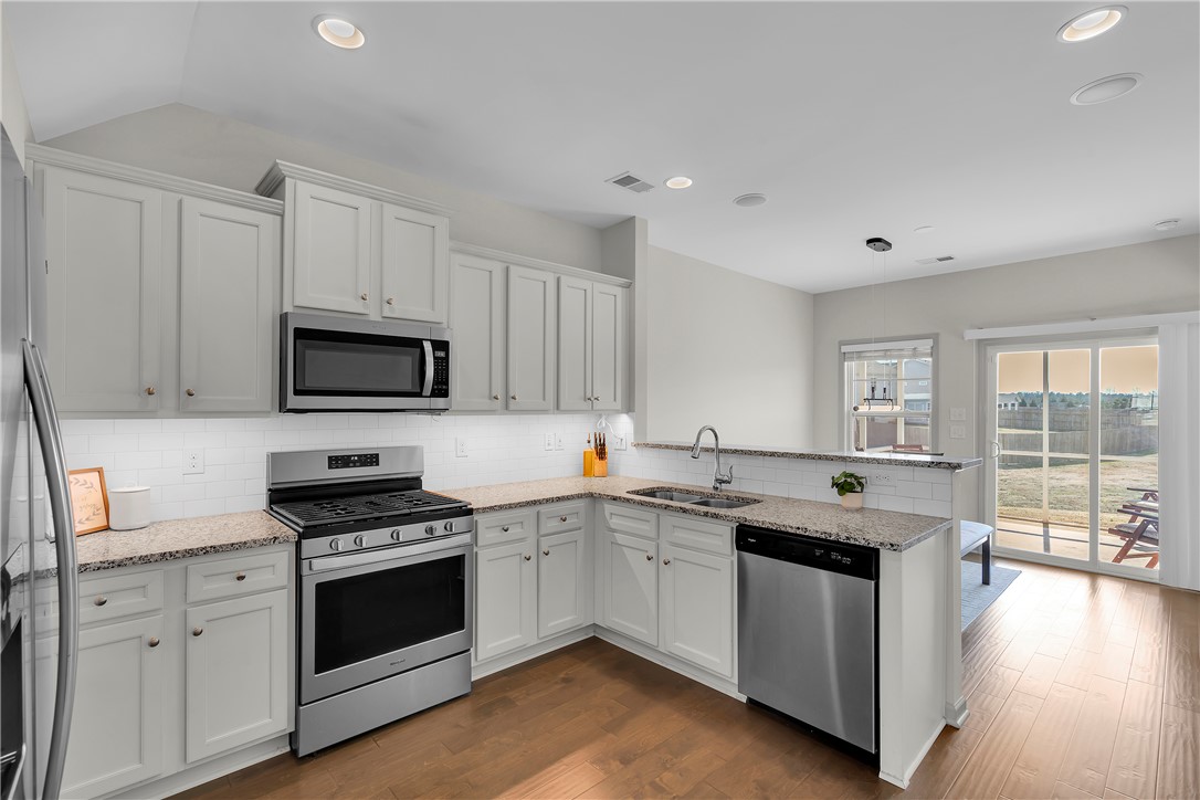302 Phillips Drive Pendleton, SC 29670 - Photo 5 of 27 This kitchen features stainless steel appliances, granite countertops, and hardwood flooring.