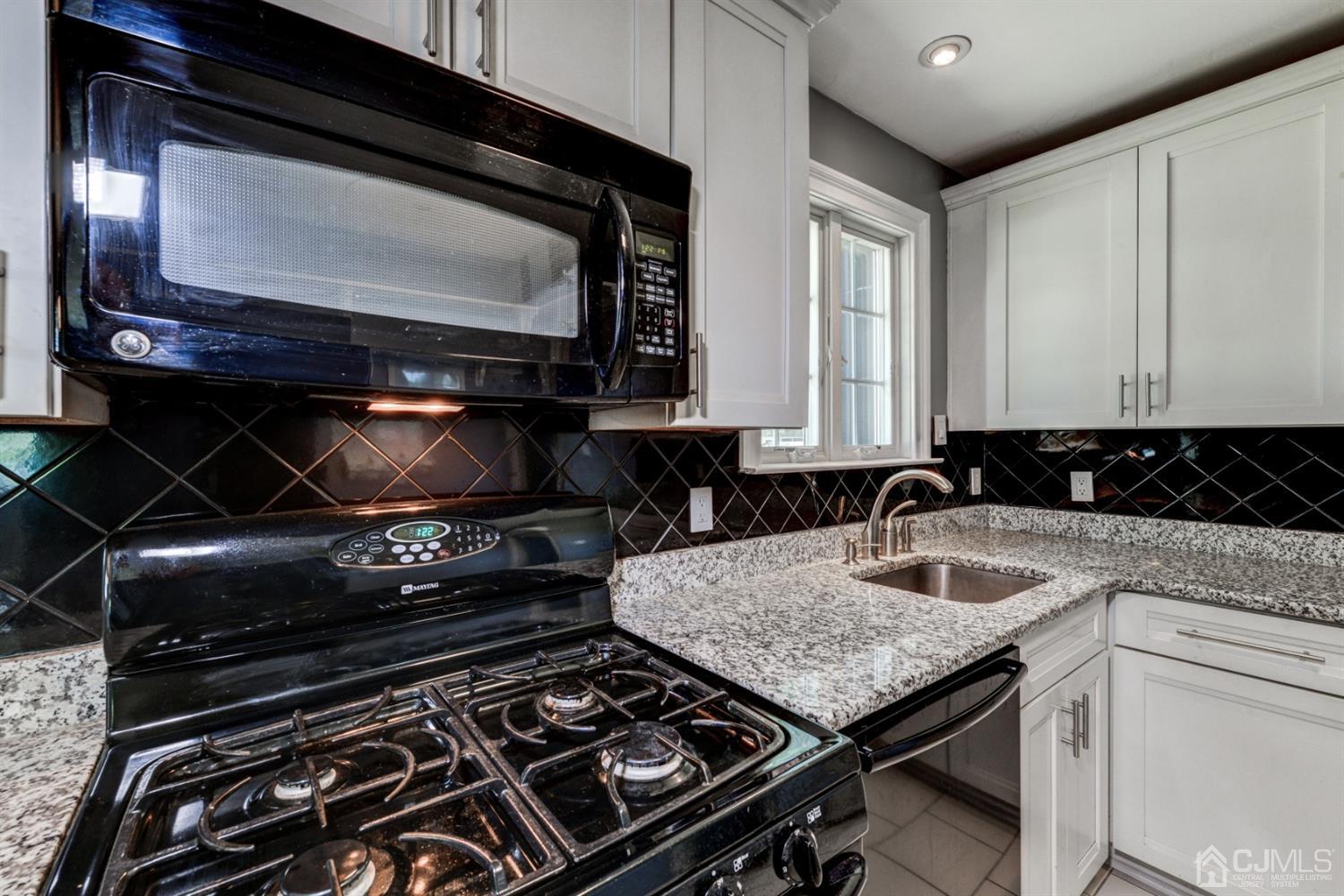 37 Finley Road Edison, NJ 08817 - Photo 12 of 29 a kitchen with a stove and a microwave