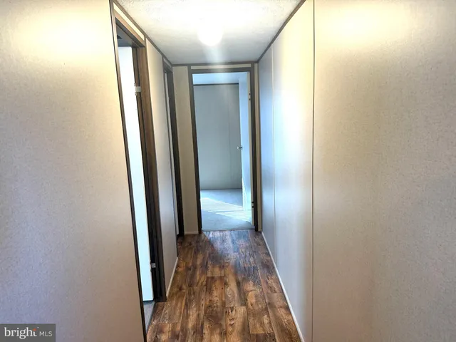 a view of hallway with wooden floor