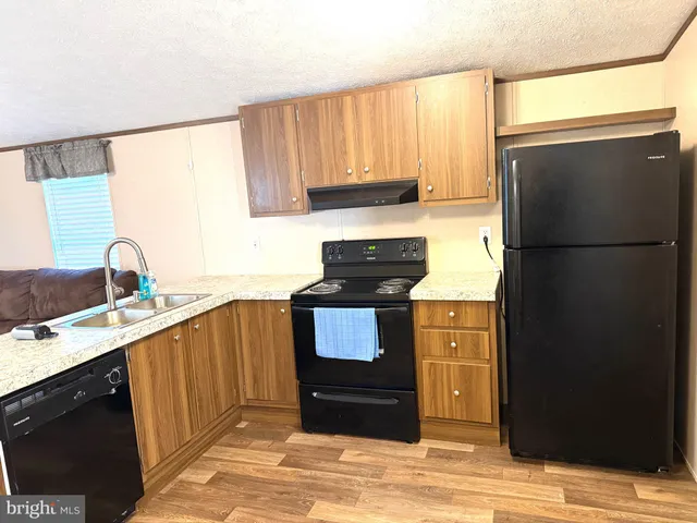 a kitchen with granite countertop a refrigerator and a sink