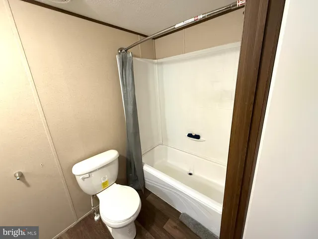a white toilet sitting next to a bathtub