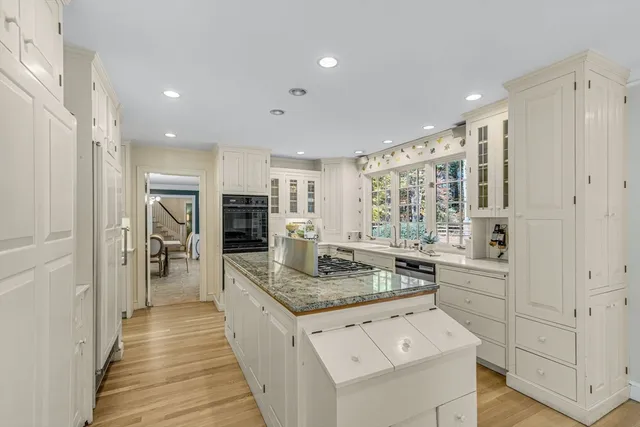 a kitchen with white cabinets and stainless steel appliances