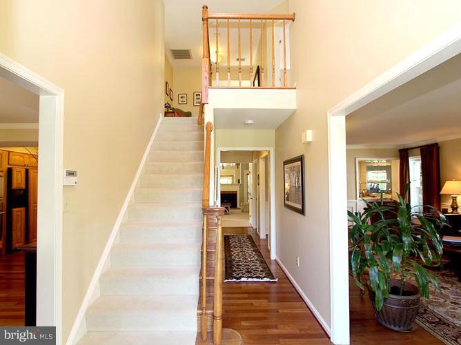8 Midsummer Court Gaithersburg, MD 20878 - Photo 3 of 30 a view of a hallway with wooden floor and a dining room