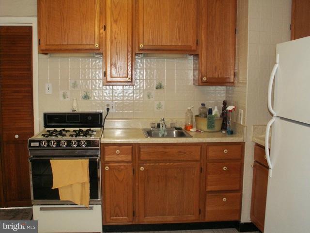 1206 Greystone Road Halethorpe, MD 21227 - Photo 4 of 10 a kitchen with stainless steel appliances wooden cabinets and a stove top oven