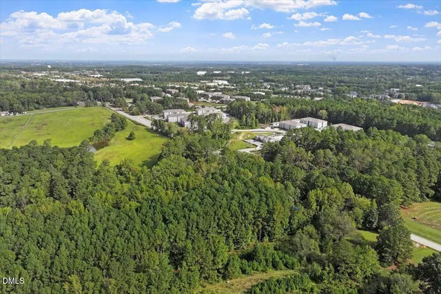 an aerial view of a houses with a lush green hillside