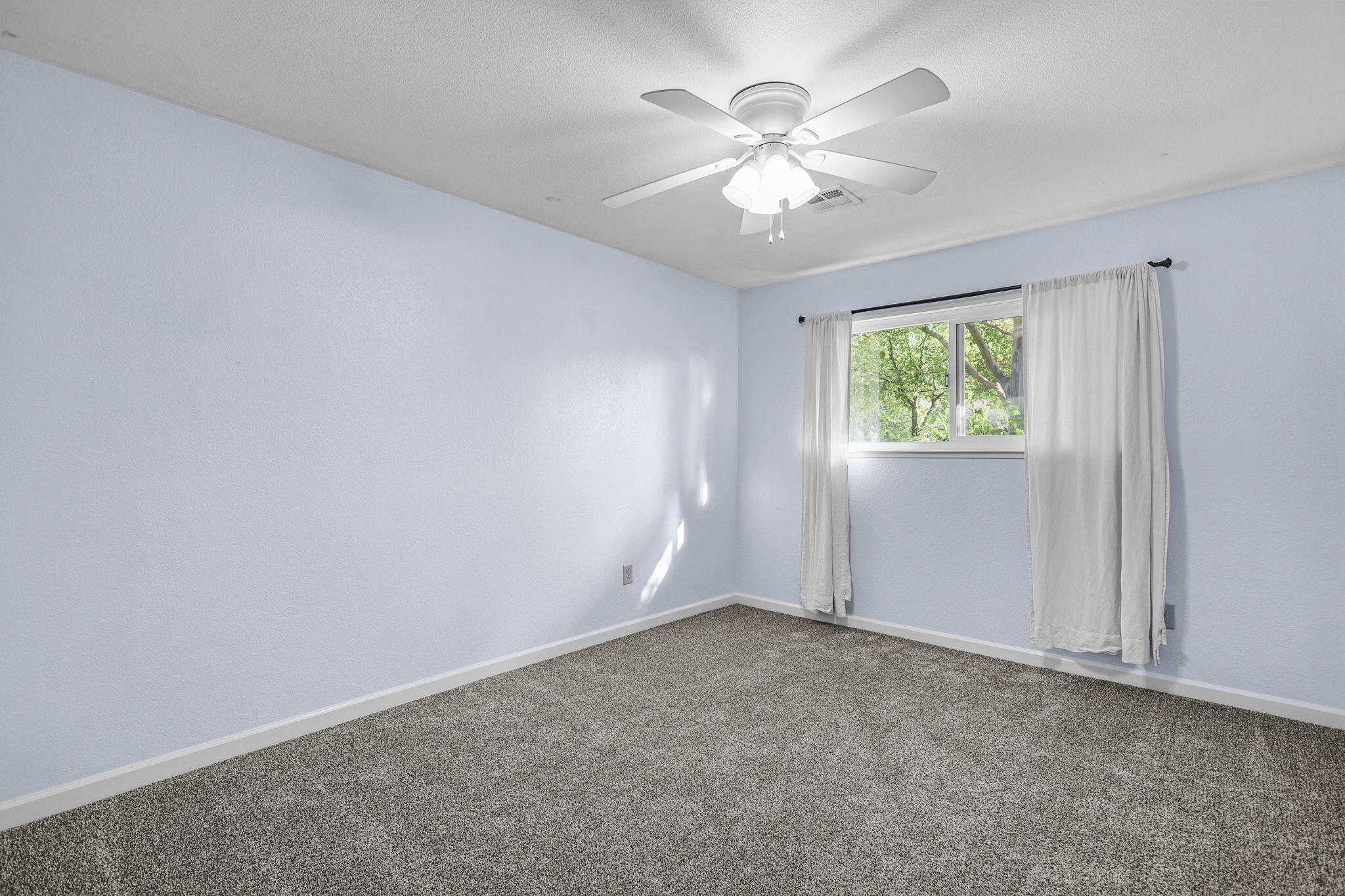 4218 Jane Street Redding, CA 96002 - Photo 27 of 50 an empty room with a chandelier fan and windows