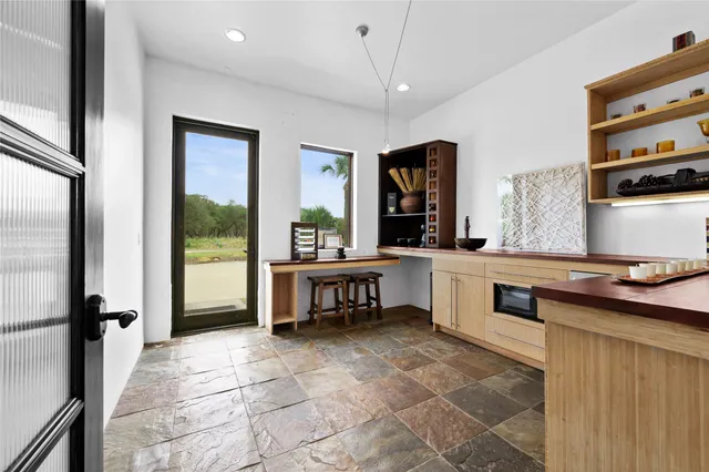 a living room with stainless steel appliances kitchen island granite countertop furniture and a fireplace