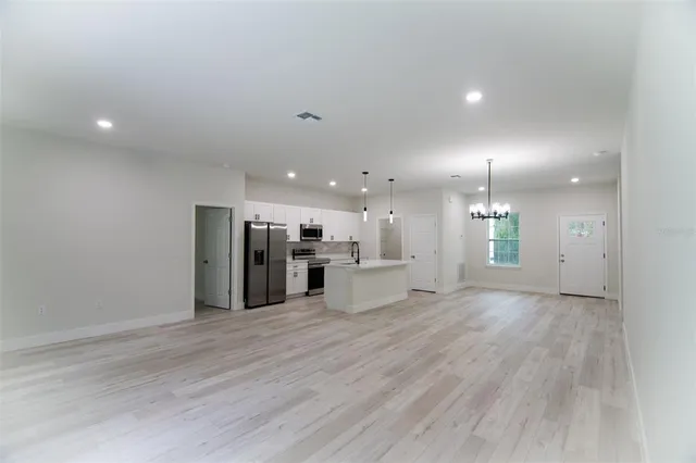 a large kitchen with granite countertop a large counter top a sink and appliances