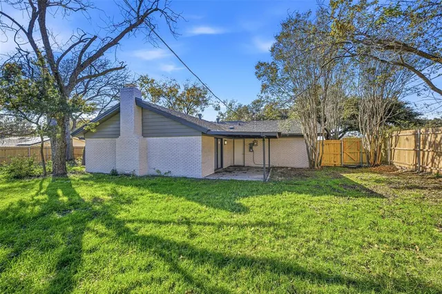 a view of a house with backyard and tree