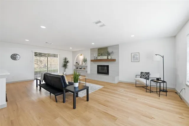 a living room with furniture a fireplace and a dining table with wooden floor