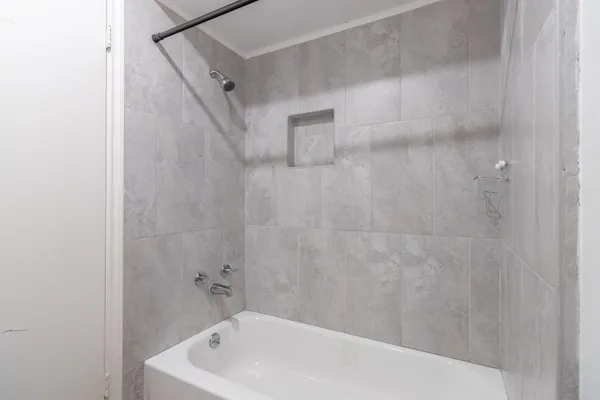 a bathroom with a white bath tub and a shower