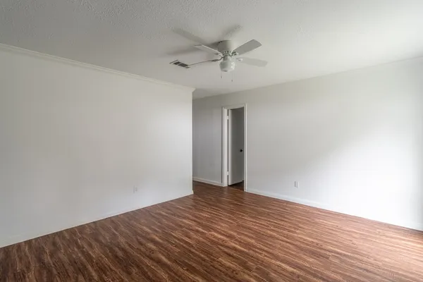 a view of an empty room with wooden floor