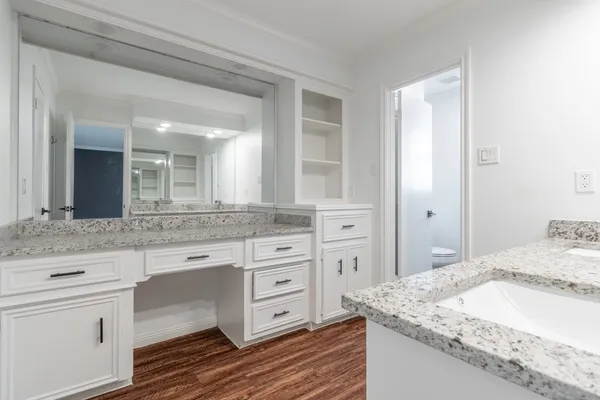 a spacious bathroom with a granite countertop sink and a mirror