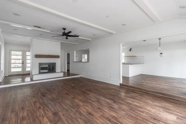a view of an empty room with a fireplace and a window