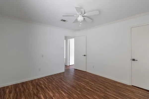 a view of an empty room with wooden floor