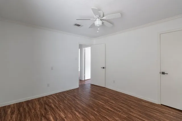 a view of an empty room with wooden floor