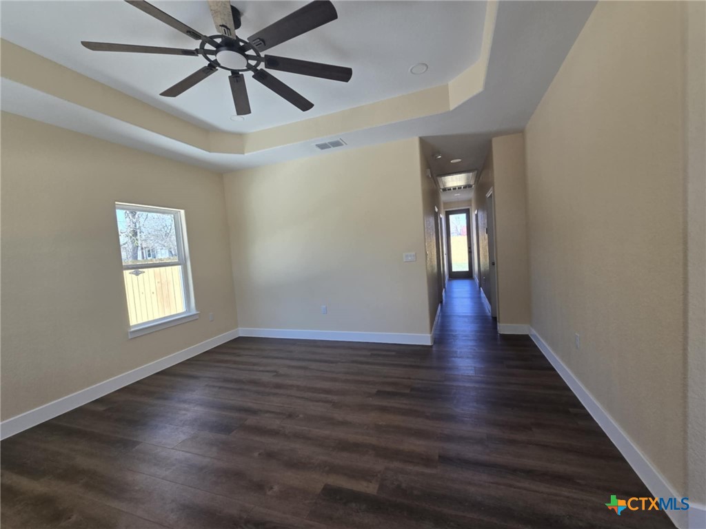410 Trinity Street Luling, TX 78648 - Photo 3 of 10 a view of an empty room with wooden floor and a window