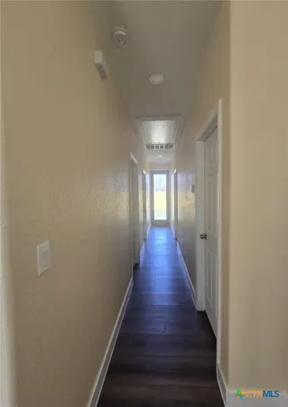 a hallway with wooden floor and staircase