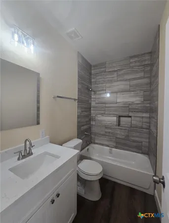 a bathroom with a bathtub shower sink vanity and toilet