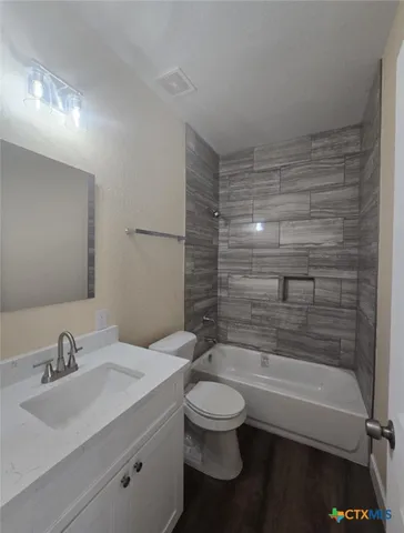 a bathroom with a bathtub shower sink vanity and toilet