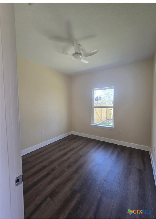 410 Trinity Street Luling, TX 78648 - Photo 8 of 10 an empty room with wooden floor ceiling fan and window