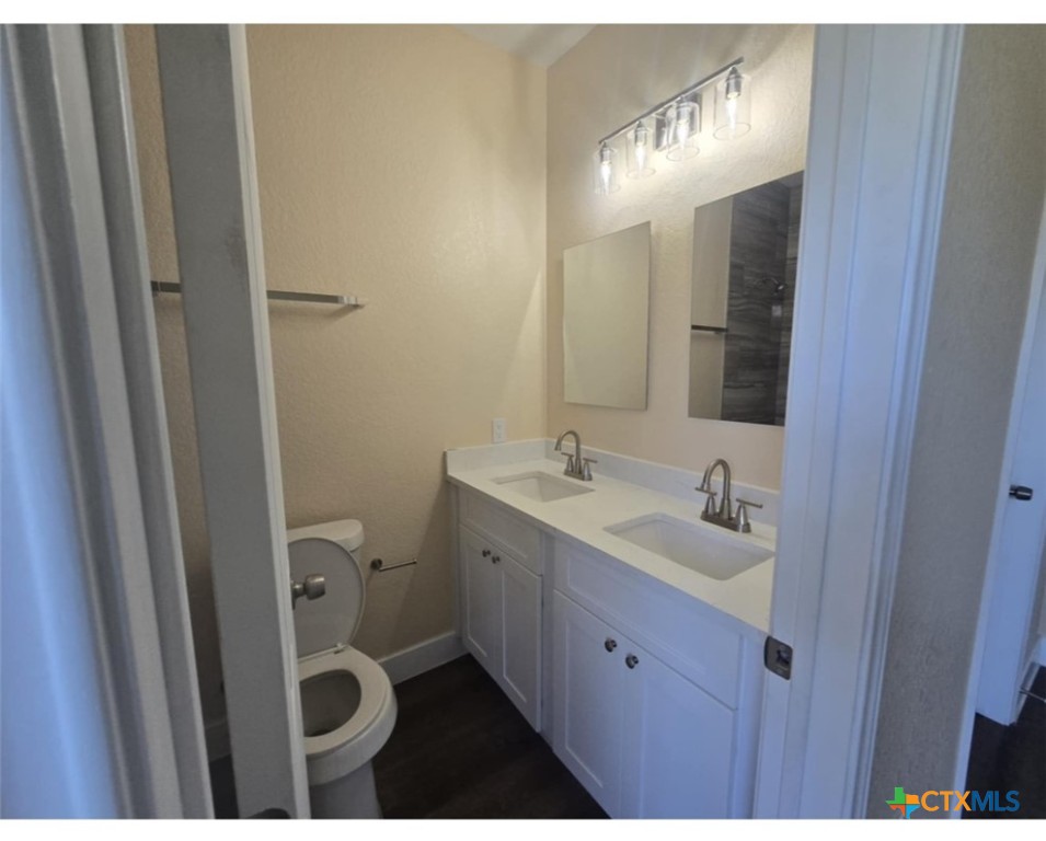 410 Trinity Street Luling, TX 78648 - Photo 10 of 10 a bathroom with a sink and mirror with toilet