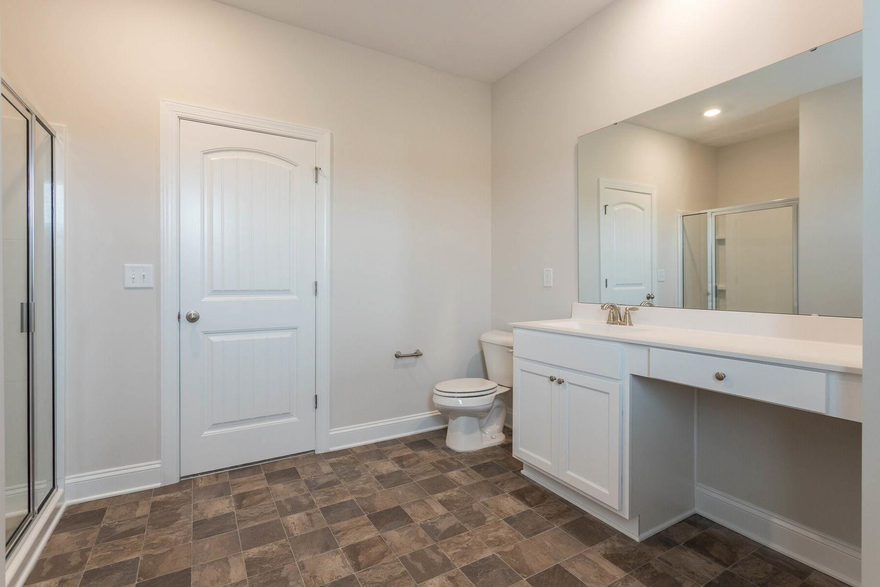 310 Access Drive Youngsville, NC 27596 - Photo 14 of 19 a spacious bathroom with a toilet sink and a mirror