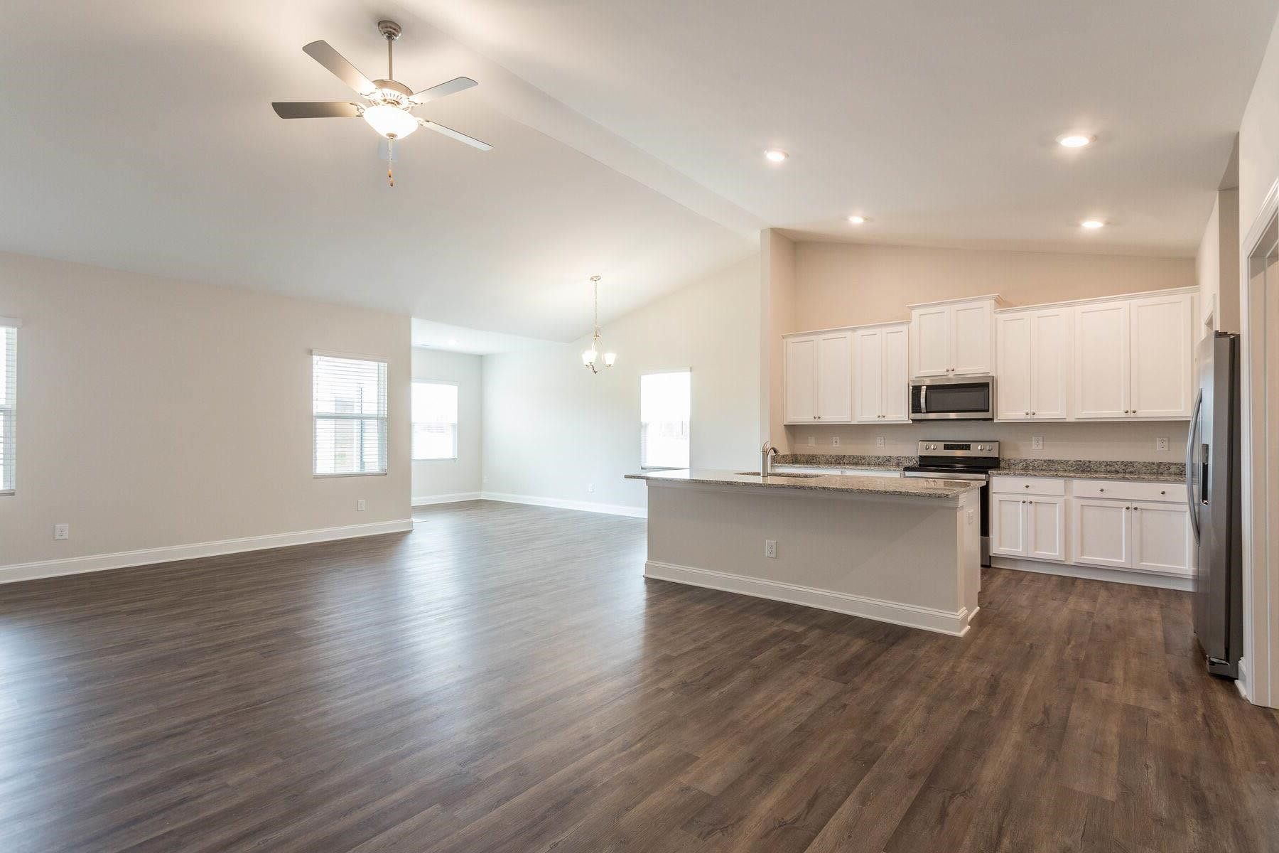 310 Access Drive Youngsville, NC 27596 - Photo 3 of 19 a view of kitchen with granite countertop stainless steel appliances cabinets a sink and a wooden floor