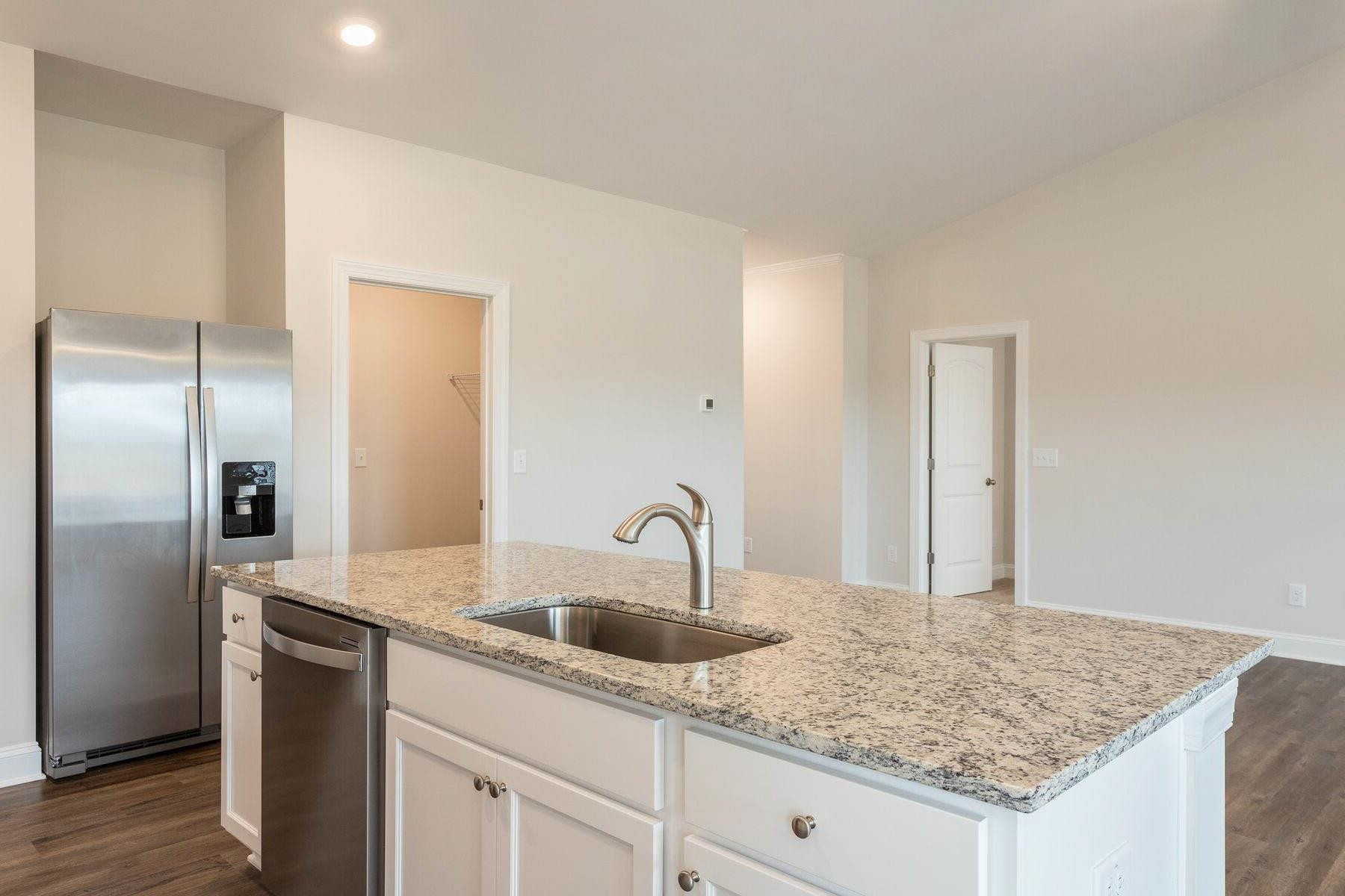 310 Access Drive Youngsville, NC 27596 - Photo 9 of 19 a kitchen with kitchen island granite countertop a sink and refrigerator