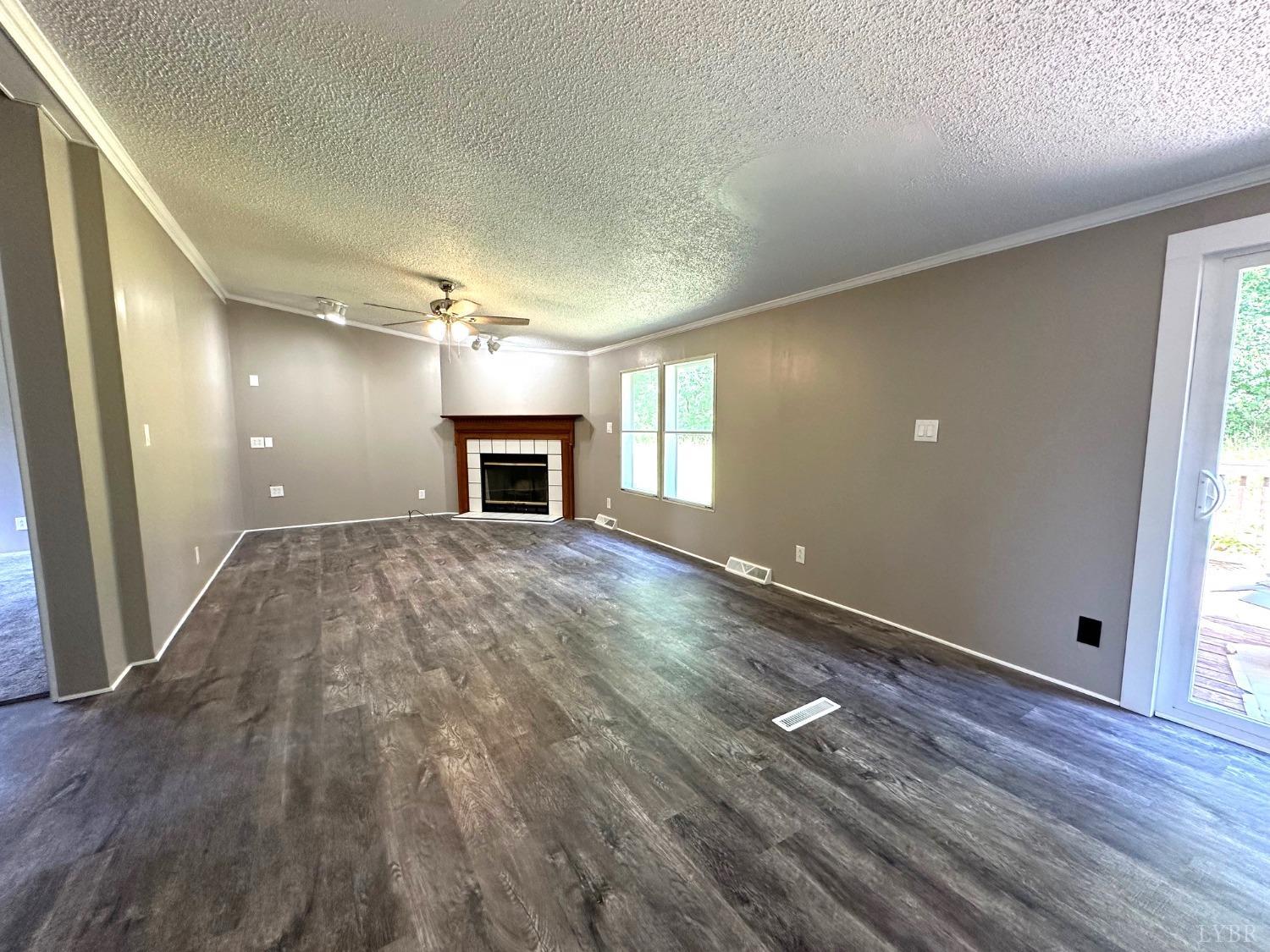 6337 Bethany Road Rustburg, VA 24588 - Photo 4 of 24 a view of empty room with wooden floor and fireplace