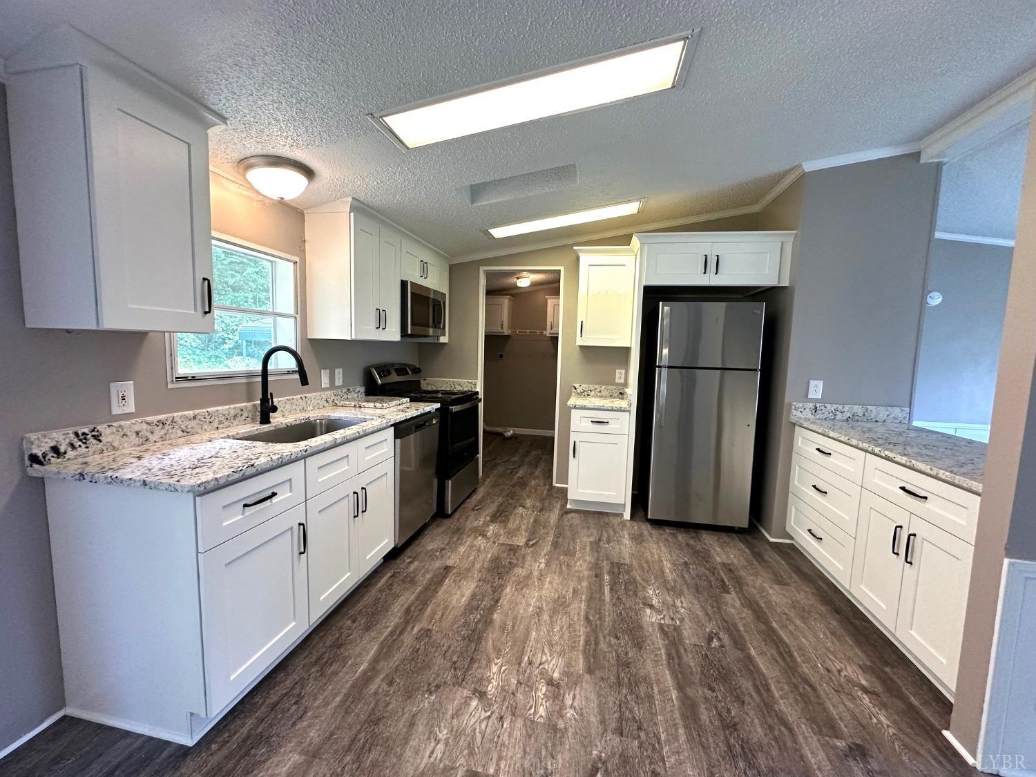 6337 Bethany Road Rustburg, VA 24588 - Photo 6 of 24 a kitchen with granite countertop white cabinets and white appliances