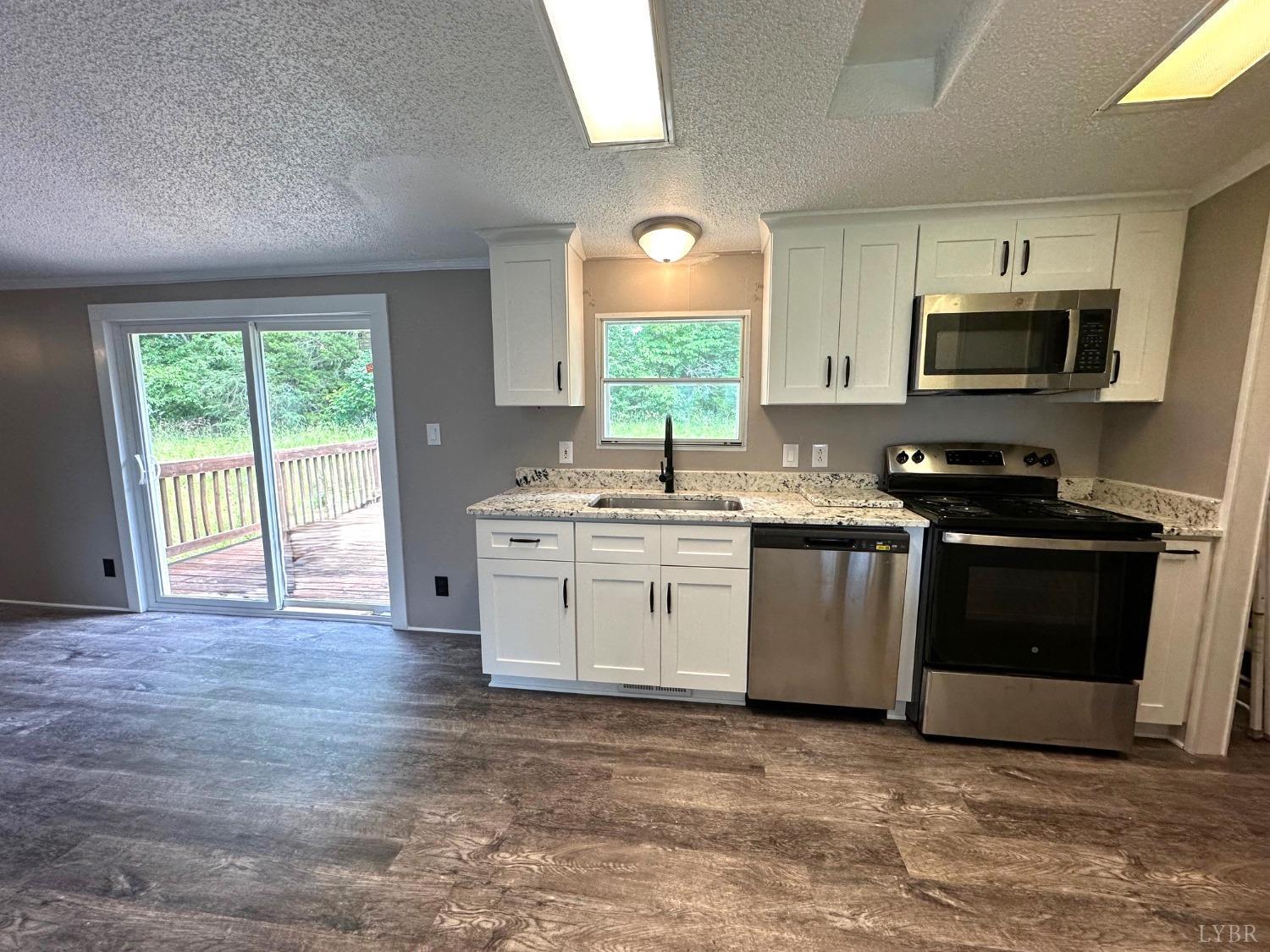 6337 Bethany Road Rustburg, VA 24588 - Photo 7 of 24 a kitchen with stainless steel appliances granite countertop a stove a sink and a microwave