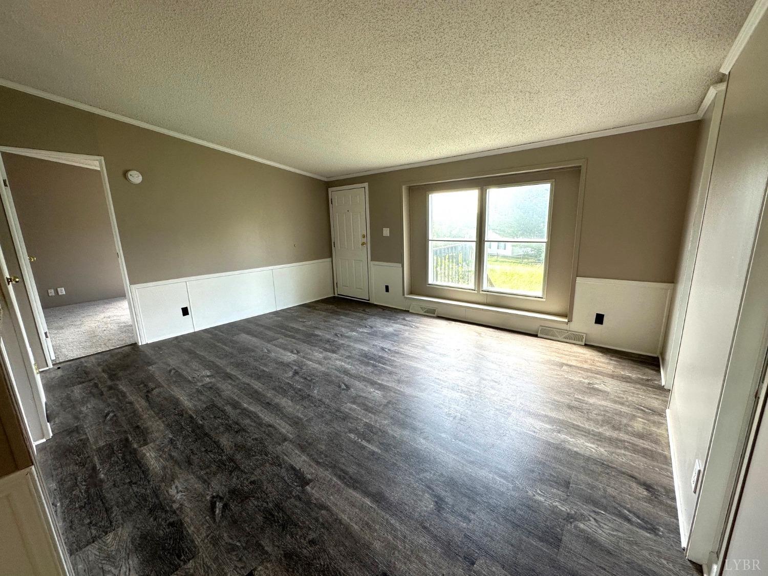 6337 Bethany Road Rustburg, VA 24588 - Photo 9 of 24 an empty room with wooden floor and windows
