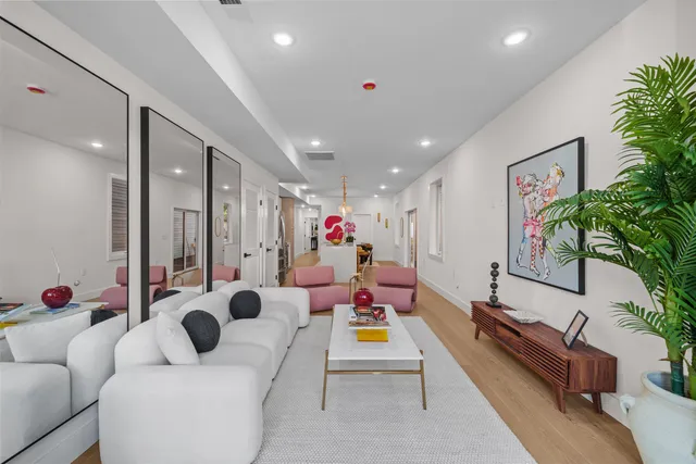 a living room with furniture potted plant and a large mirror