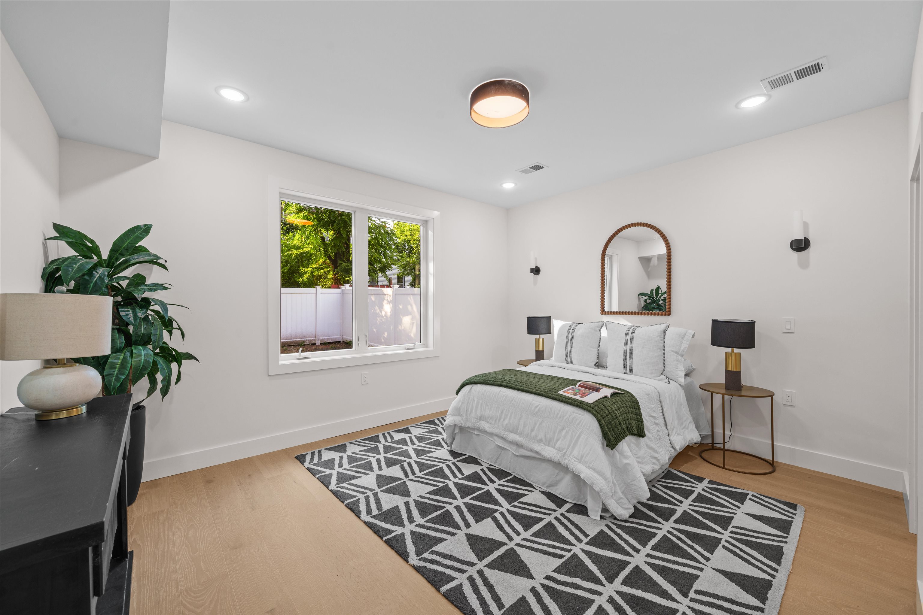 249.5 Halladay Street, Unit 1 Jersey City, NJ 07304 - Photo 14 of 31 a bedroom with a bed and a potted plant