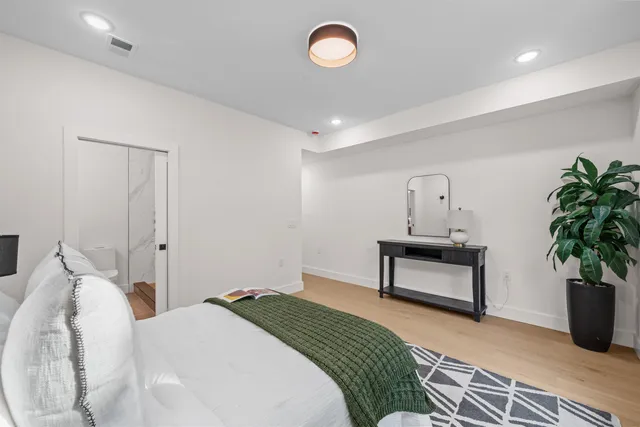 a bedroom with bed and a potted plant