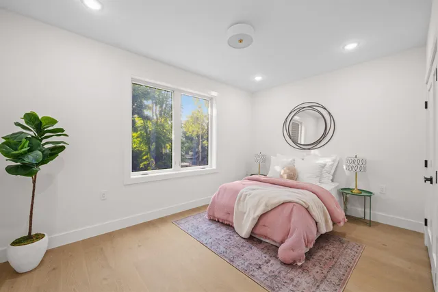 a bedroom with a bed lamp and a potted plant