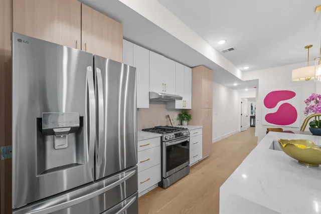 a kitchen with stainless steel appliances granite countertop a refrigerator sink and stove