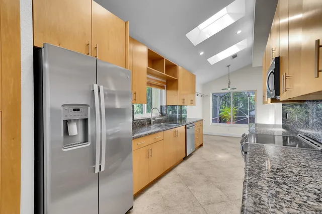 a kitchen with stainless steel appliances granite countertop a sink and a stove