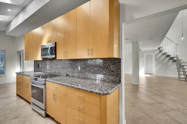 a view of an empty room with a window and cabinet